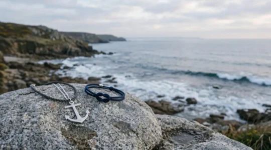 Bracelet et pendentif marins en argent poses sur un rocher face a l'ocean, incarnant l'elegance discrete du bord de mer francais
